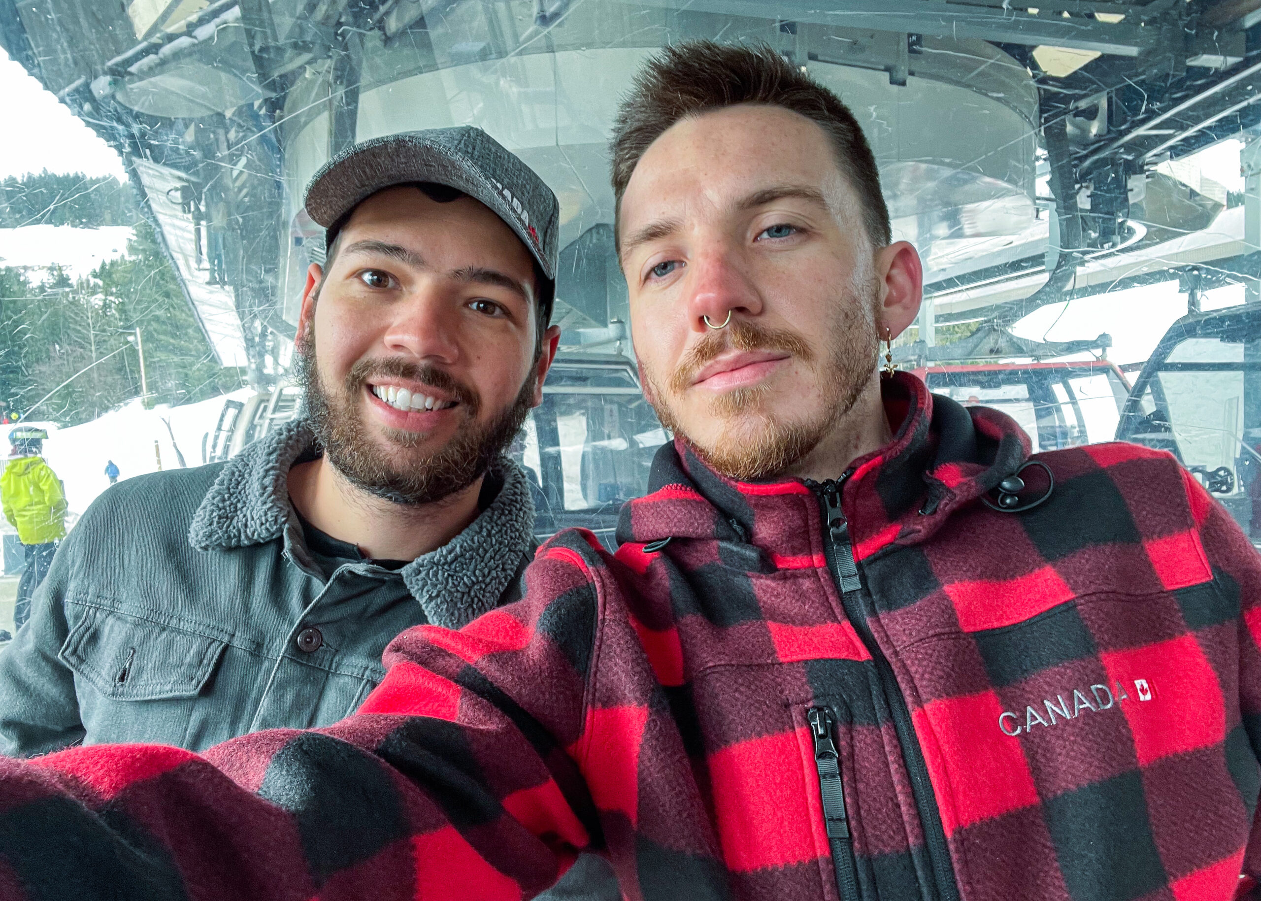 Gay digital nomad couple in a ski lift in Whistler, British Columbia, Canada