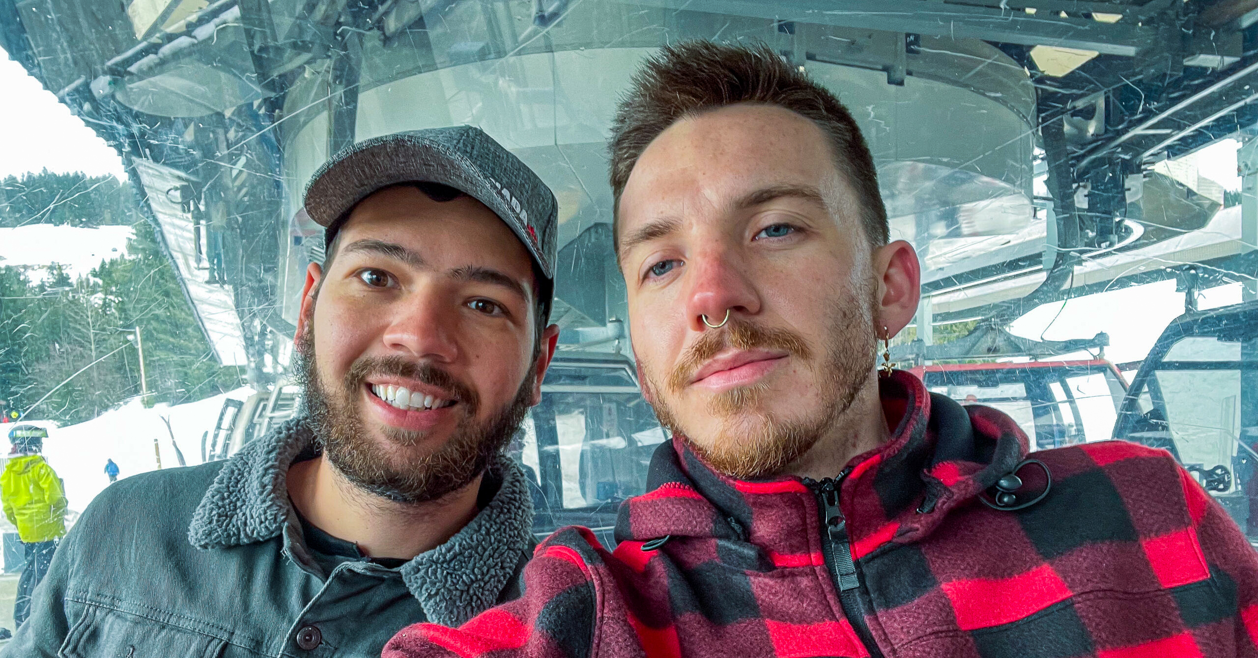 Gay digital nomad couple in a ski lift in Whistler, British Columbia, Canada